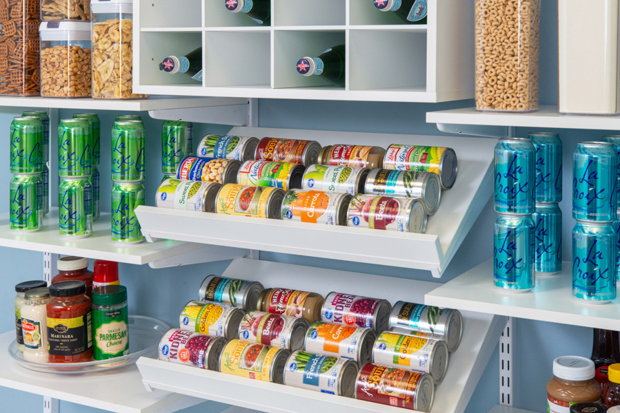 freedomRail Reach-in Pantry in White with tiered shelves with canned food items, turn tables and beverages with blue walls.
