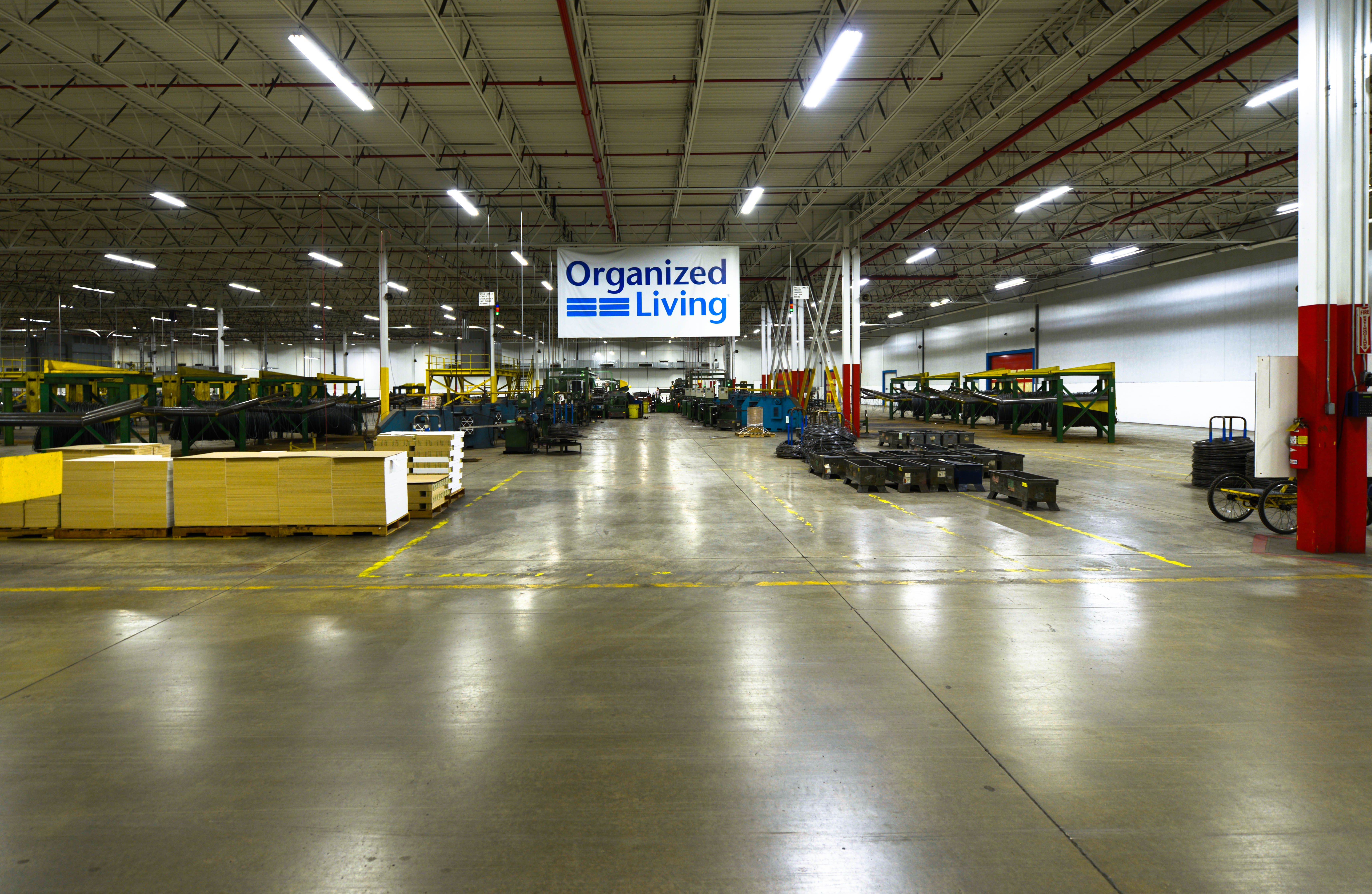 Organized Living Bloomington manufacturing facility with banner and machinery.