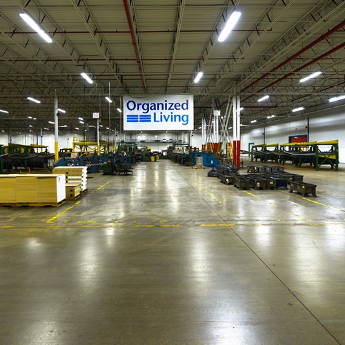 Organized Living Bloomington manufacturing facility with banner and machinery.