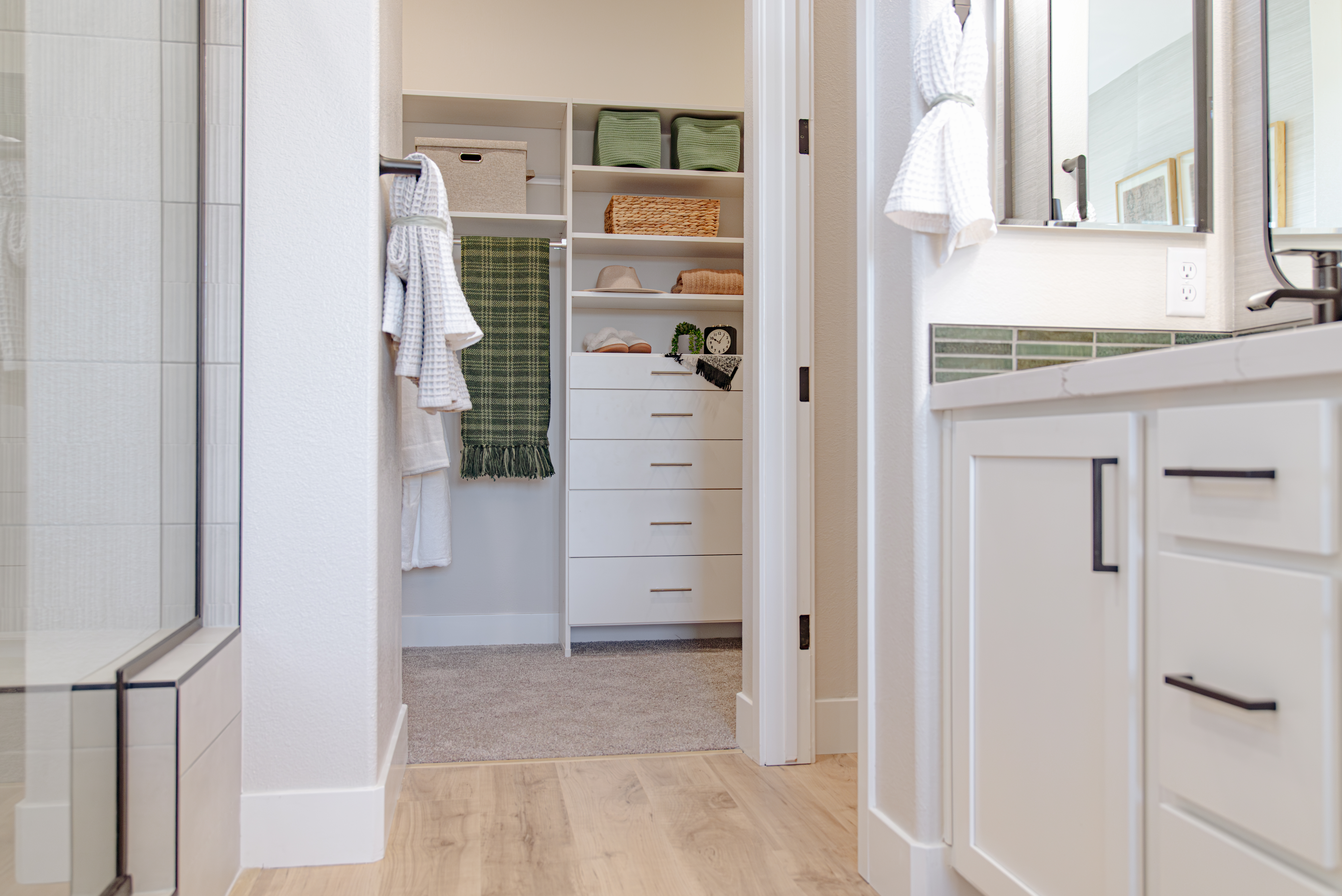 Beazer Vision House - Select Walk-in Closet in White with green accents, bathroom cabinetry, and neutral floors.