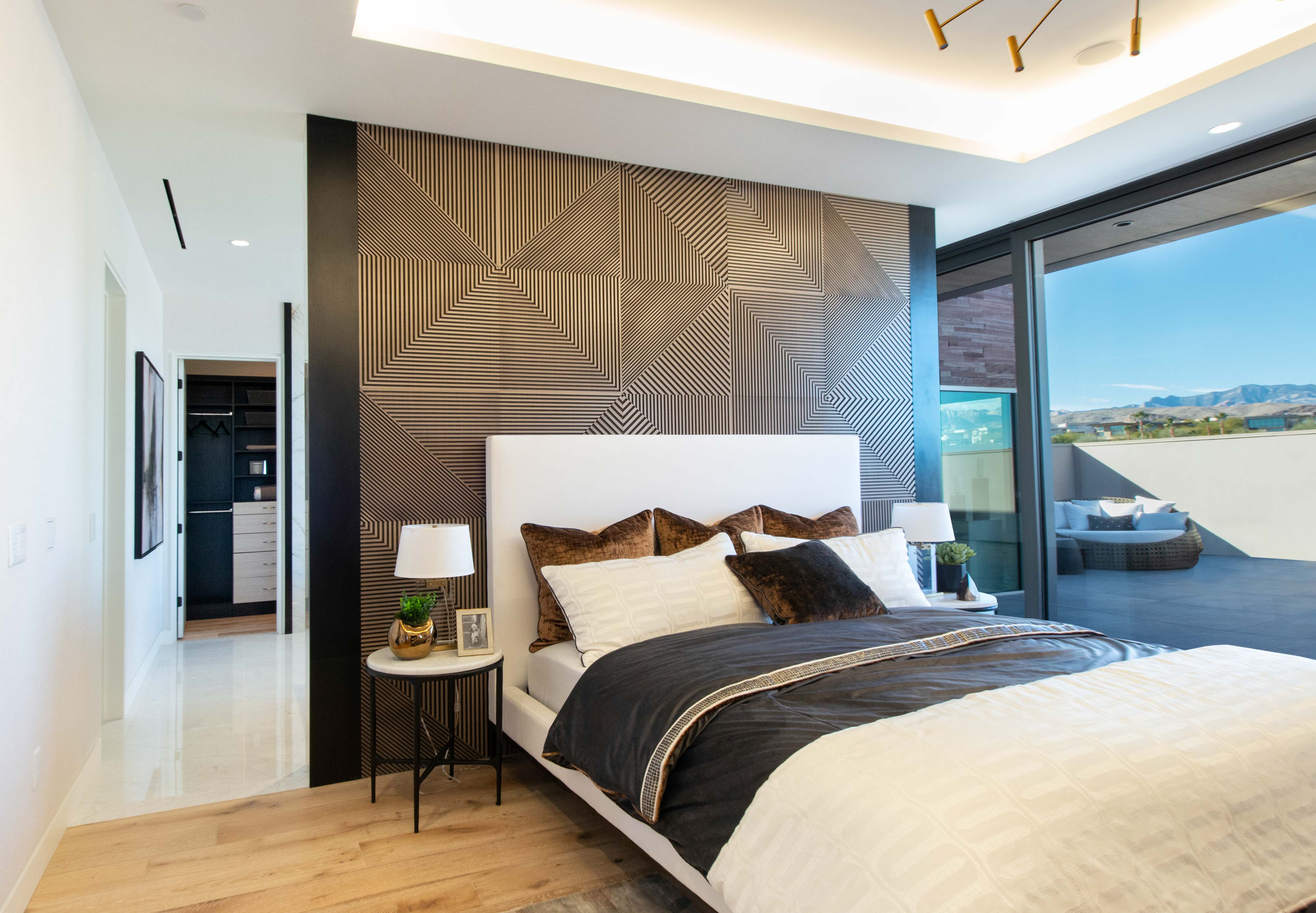 Chowa House Primary Bedroom with dark colors, landscape view out window, and metallic accent wall.
