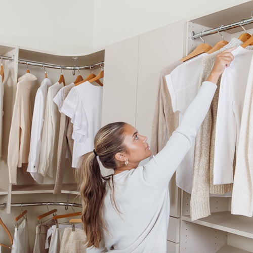 Classica Walk-in Closet in Truffle with woman grabbing shirt, neutral clothing, and cream background.