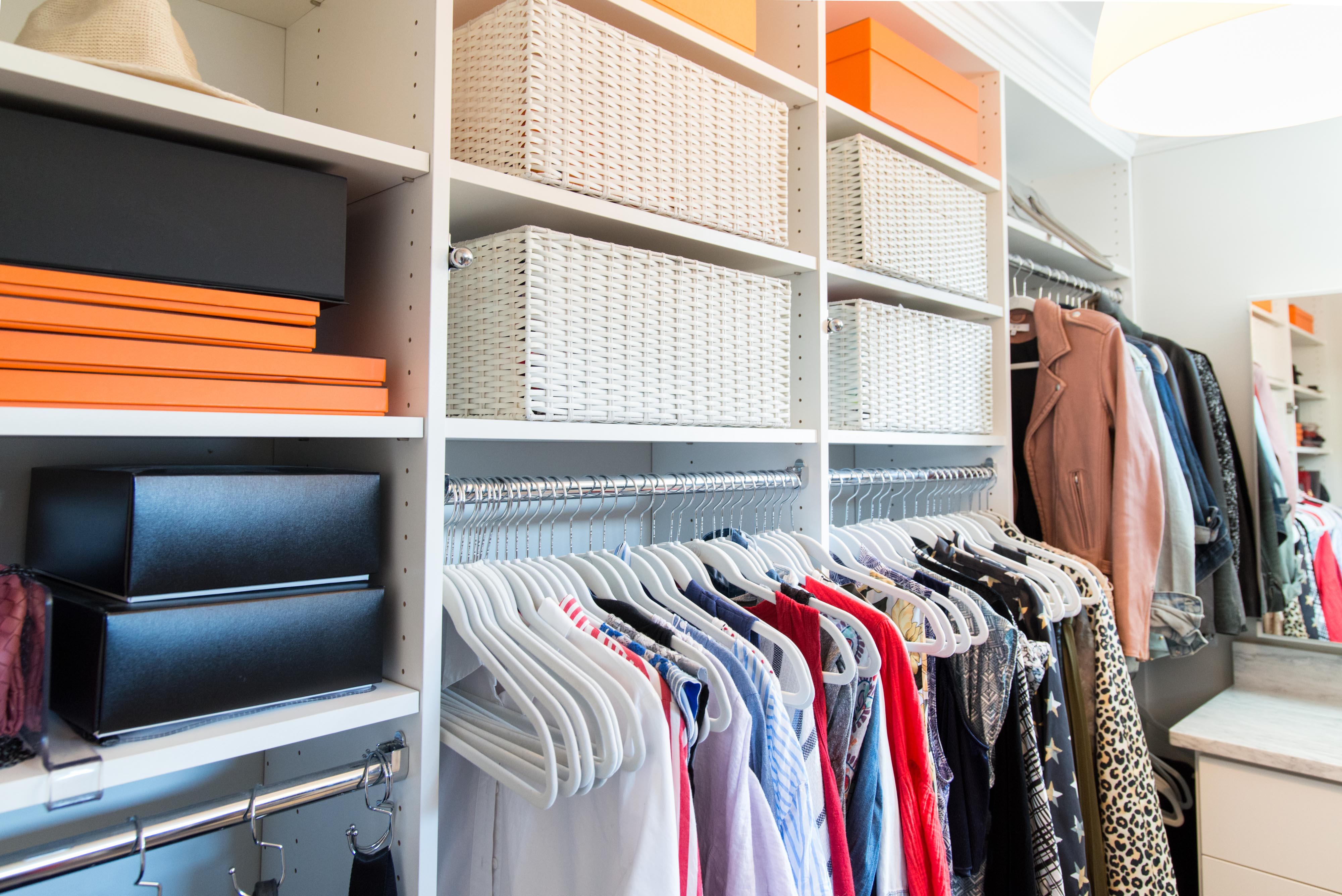 Classica Walk in Closet in White with women's clothes and baskets.