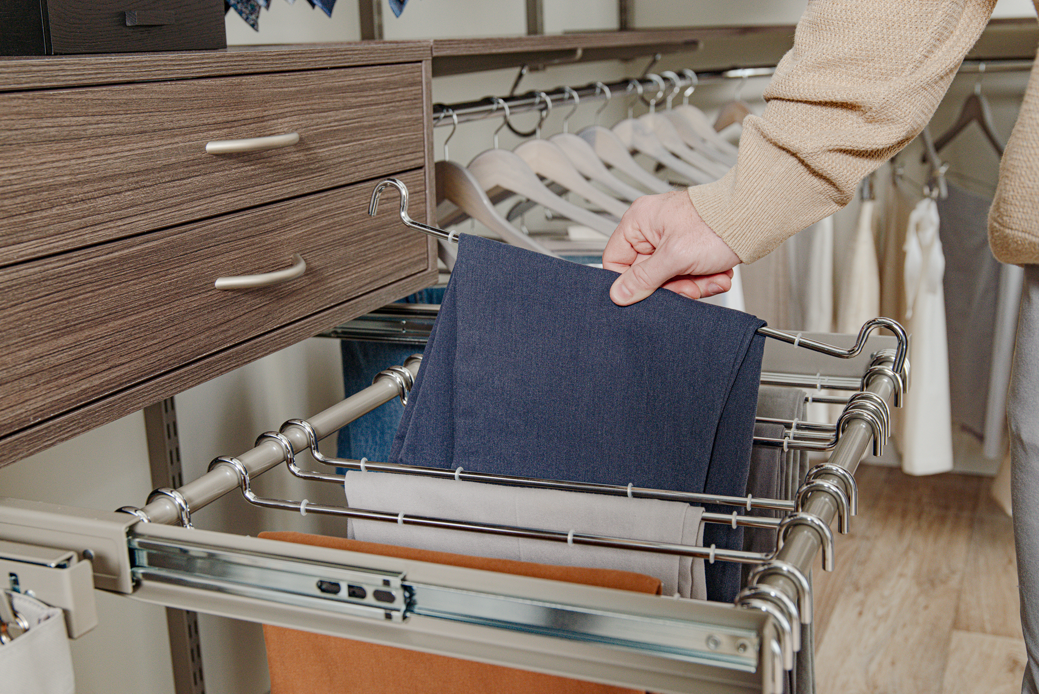 Close Up of freedomRail in Driftwood Live with reveal pant rack, drawer, and male grabbing pair of pants.