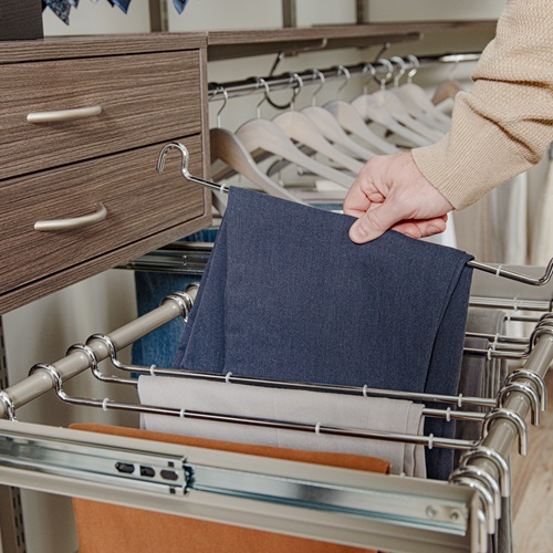 Close Up of freedomRail in Driftwood Live with reveal pant rack, drawer, and male grabbing pair of pants.