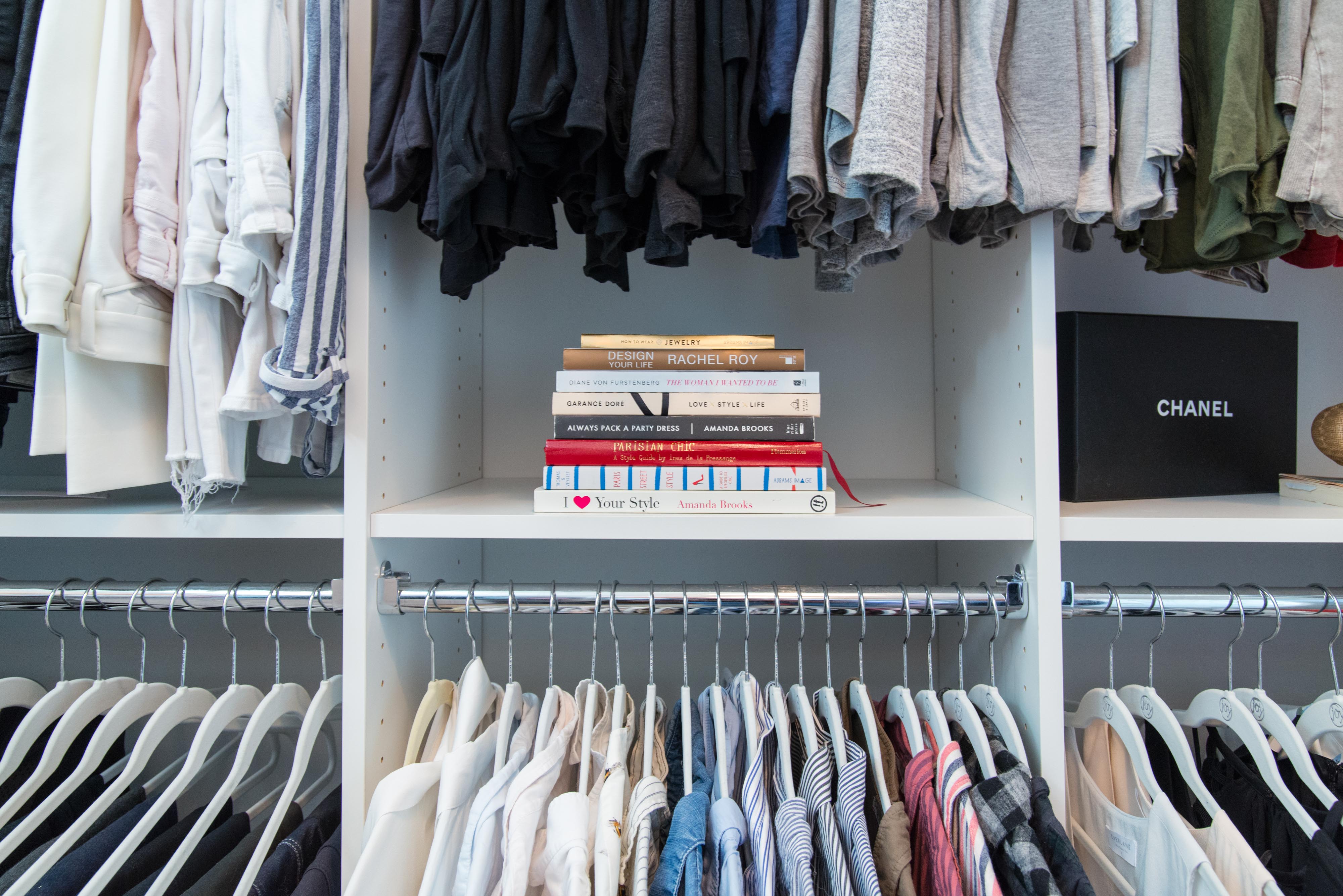 Closet in White with matching hangers and books on shelf.