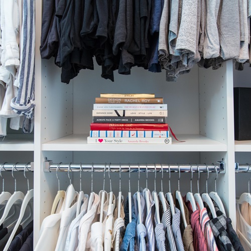 Closet in White with matching hangers and books on shelf.