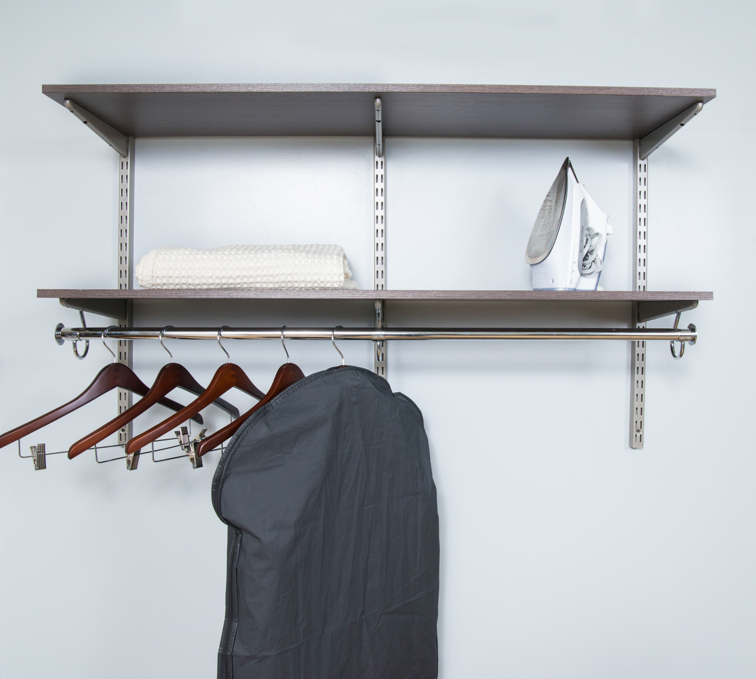 freedomRail closet in Chocolate Pear propped with men's clothing and tan walls.