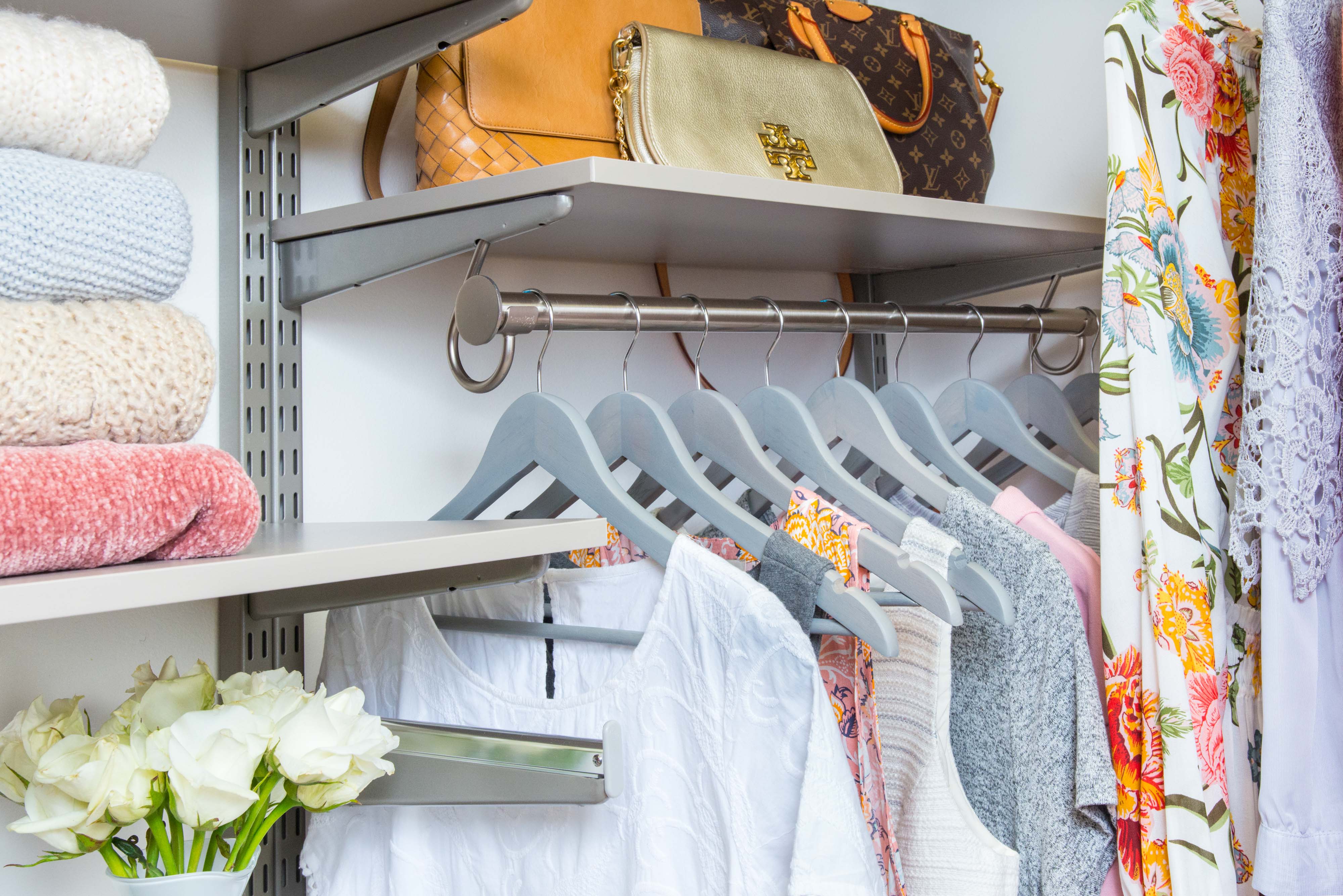 freedomRail closet in century gray with clothes hanging and there is folded clothes on the shelves.