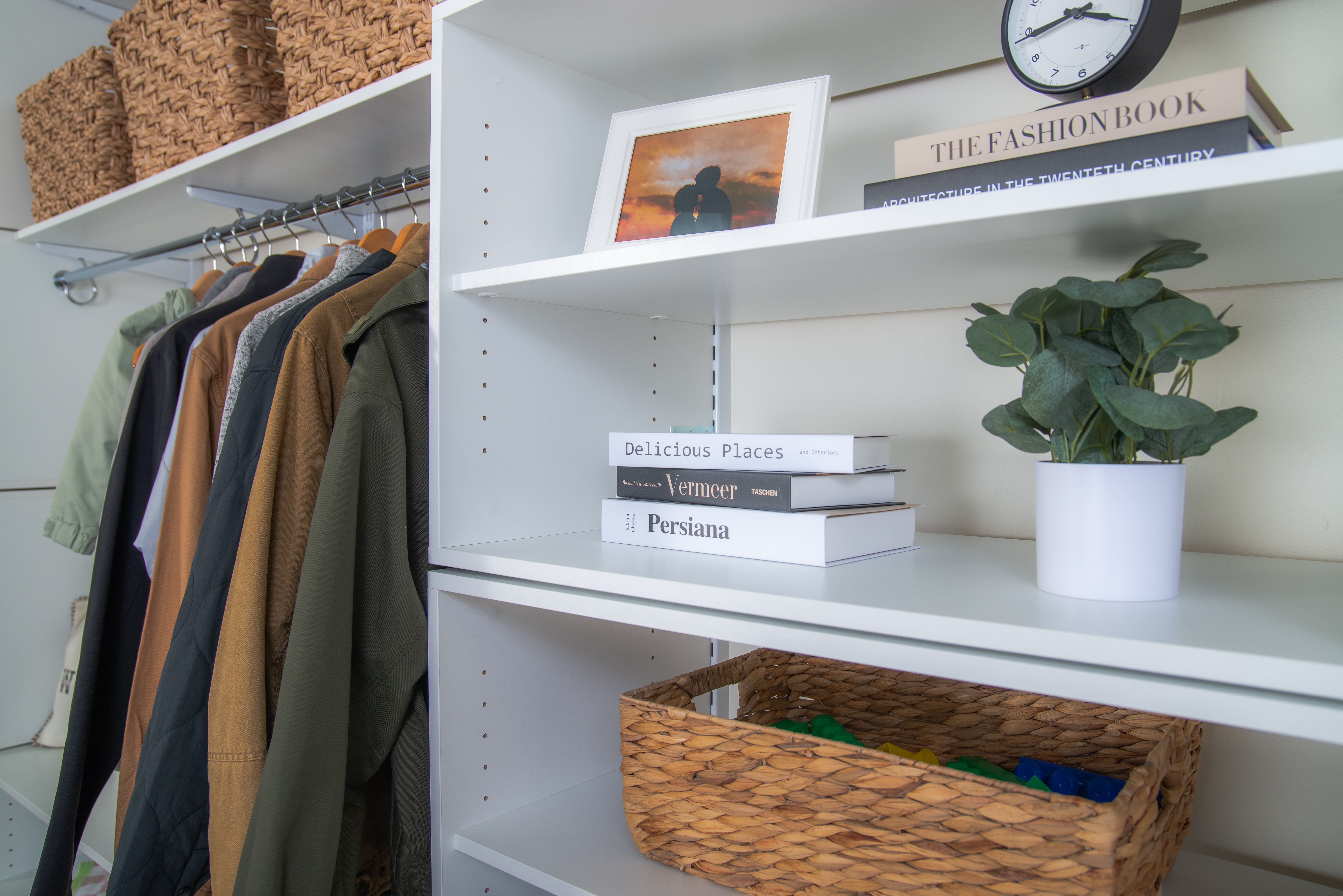 freedomRail Mudroom Entry in White with shelves of decor and jackets hanging up.