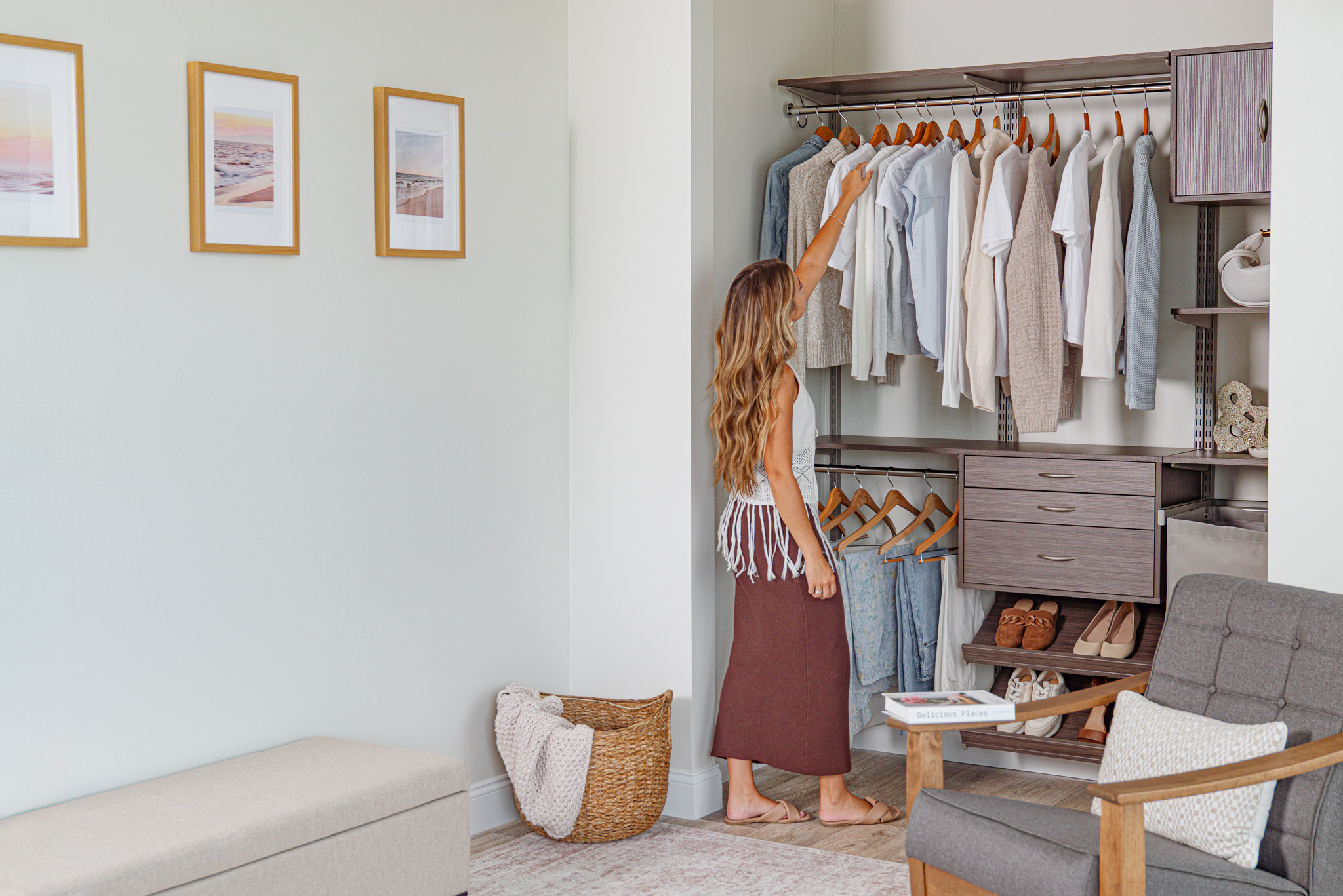 freedomRail Reach-in Closet in Driftwood Live with woman grabbing shirt and neutral background.