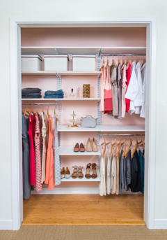 freedomRail Reach-in Closet in White with women clothes and pink background.