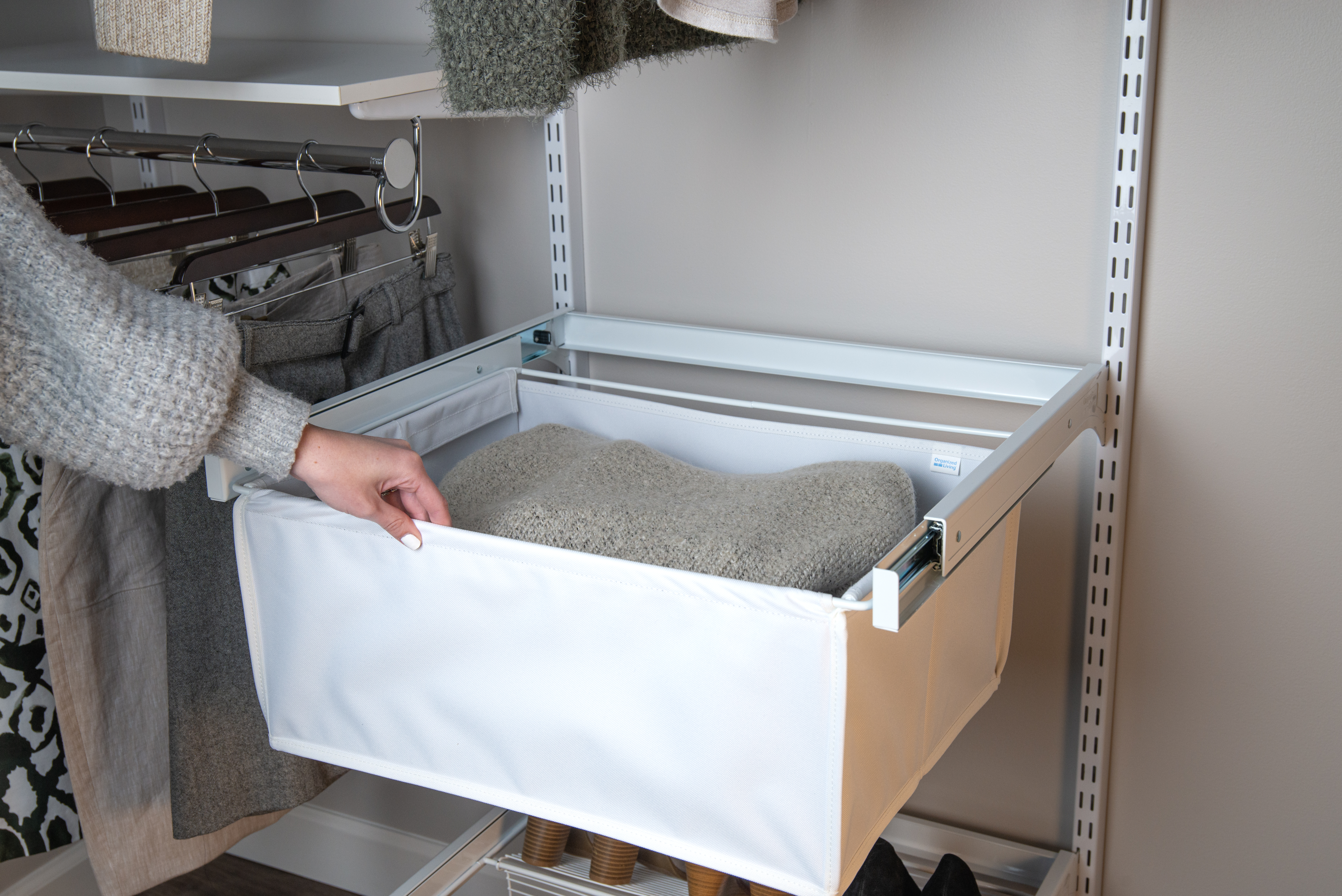 freedomRail Reach-in in White with Canvas basket and woman's hand pulling basket out. 