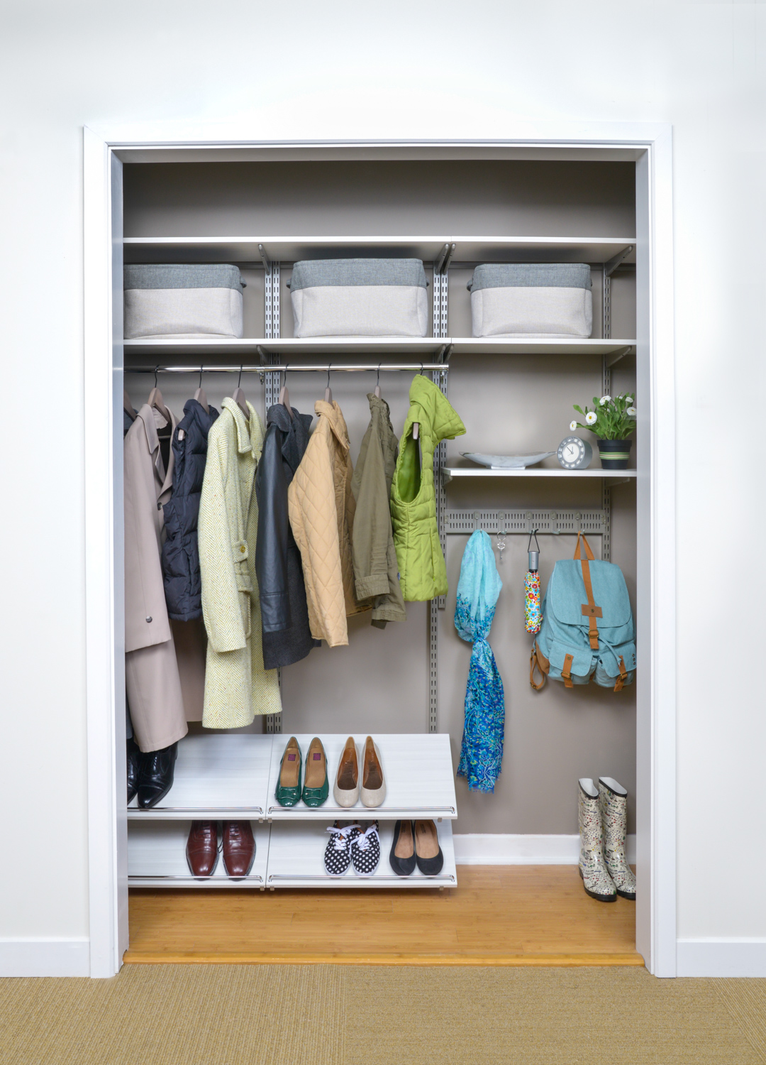 freedomRail Reach-in Closet in apartment with clothing, shoes, and storage.