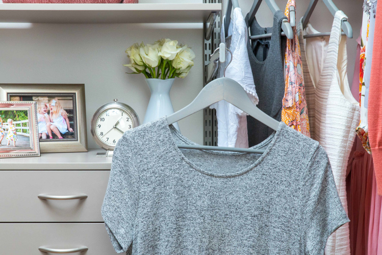 freedomRail Walk-in Closet in Century Gray with Valet Rod and women's clothes.