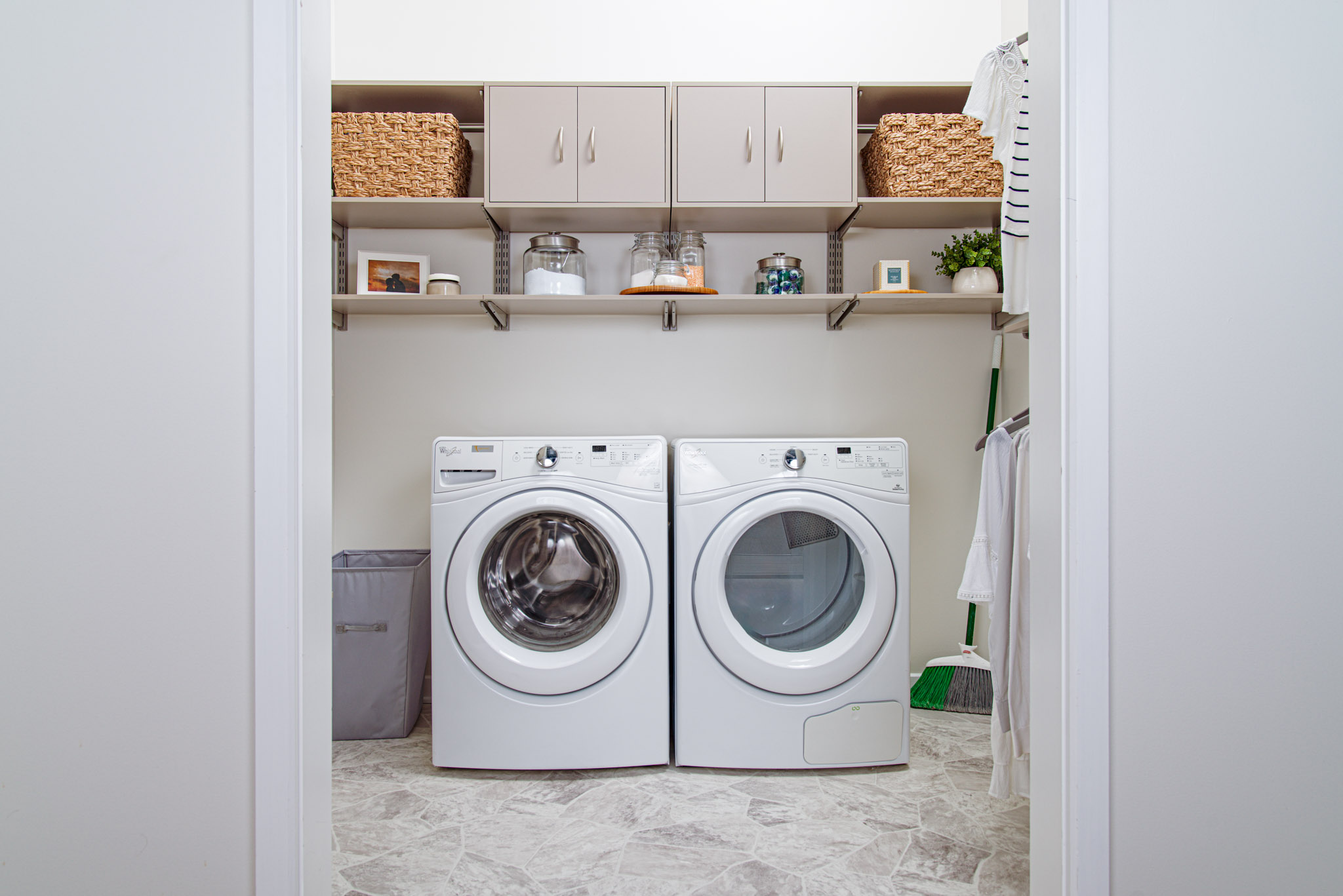 freedomrRail_Laundry_CenturyGray with white washer and dryer, wicker baskets, and laundry detergent.