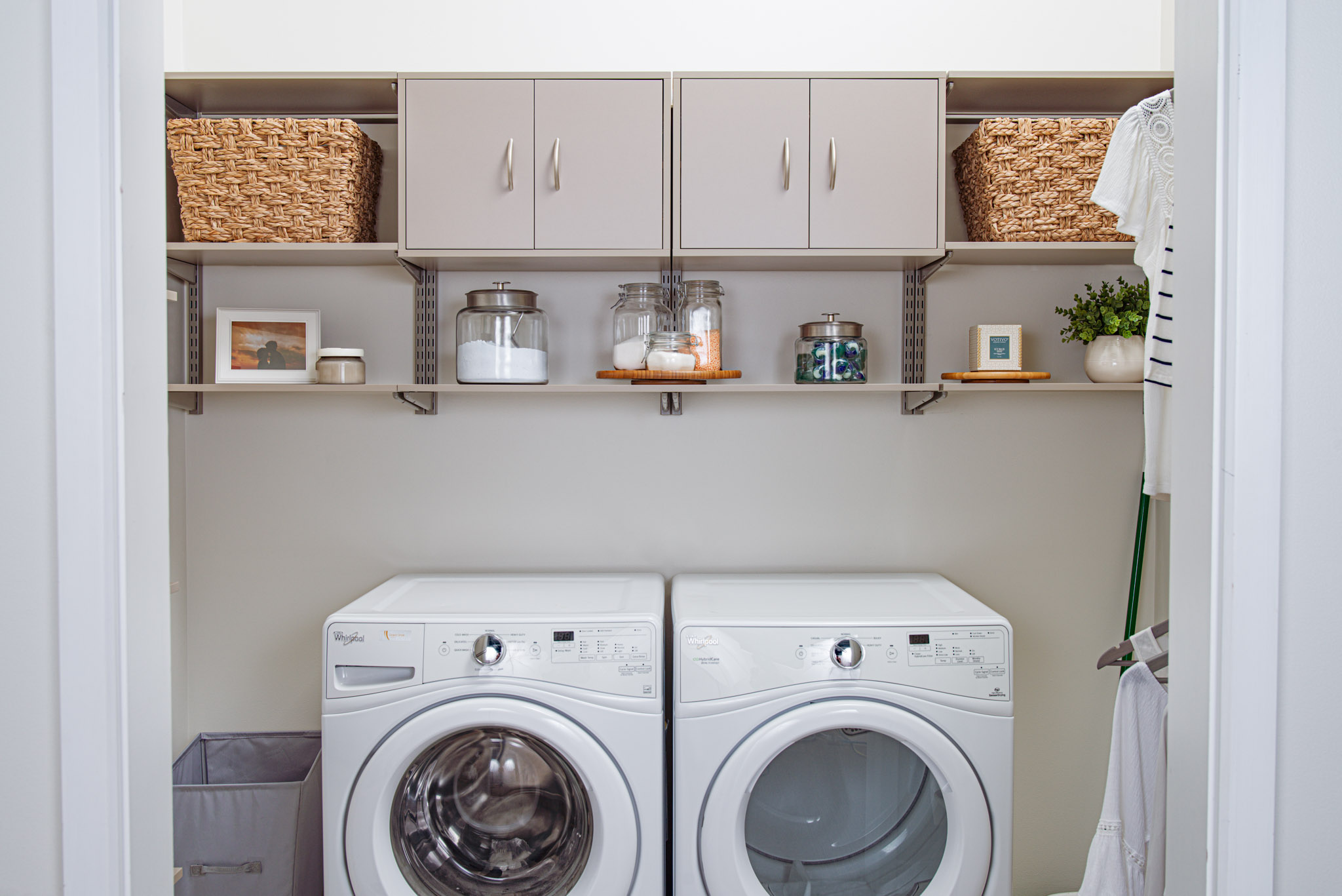 freedomrRail_Laundry_CenturyGray with white washer and dryer, wicker baskets, and neutral background.