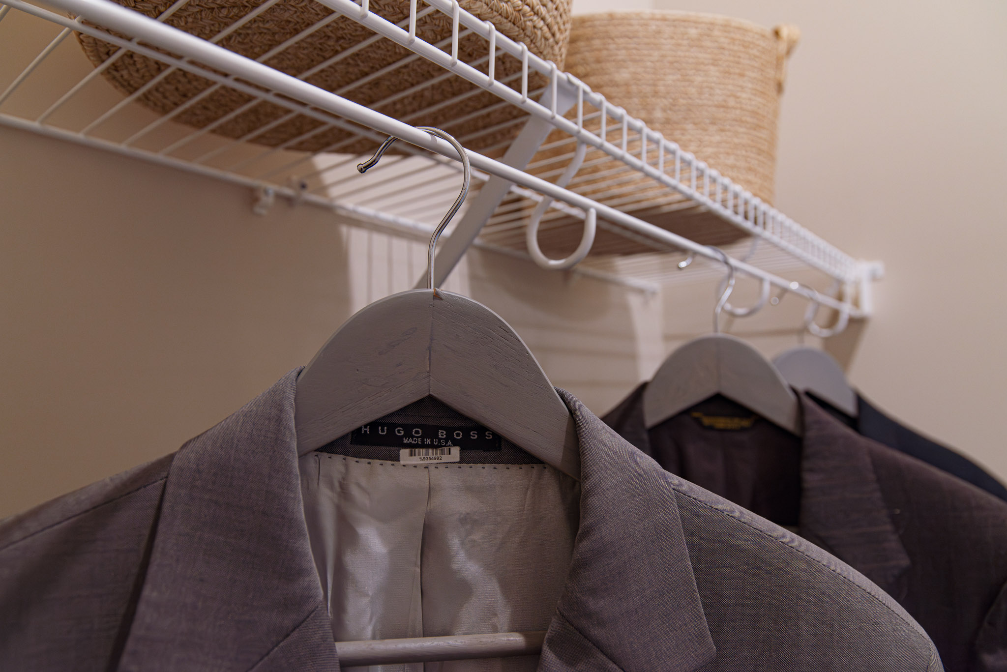 Lifetime_Bedroom_White with baskets and men's suits.