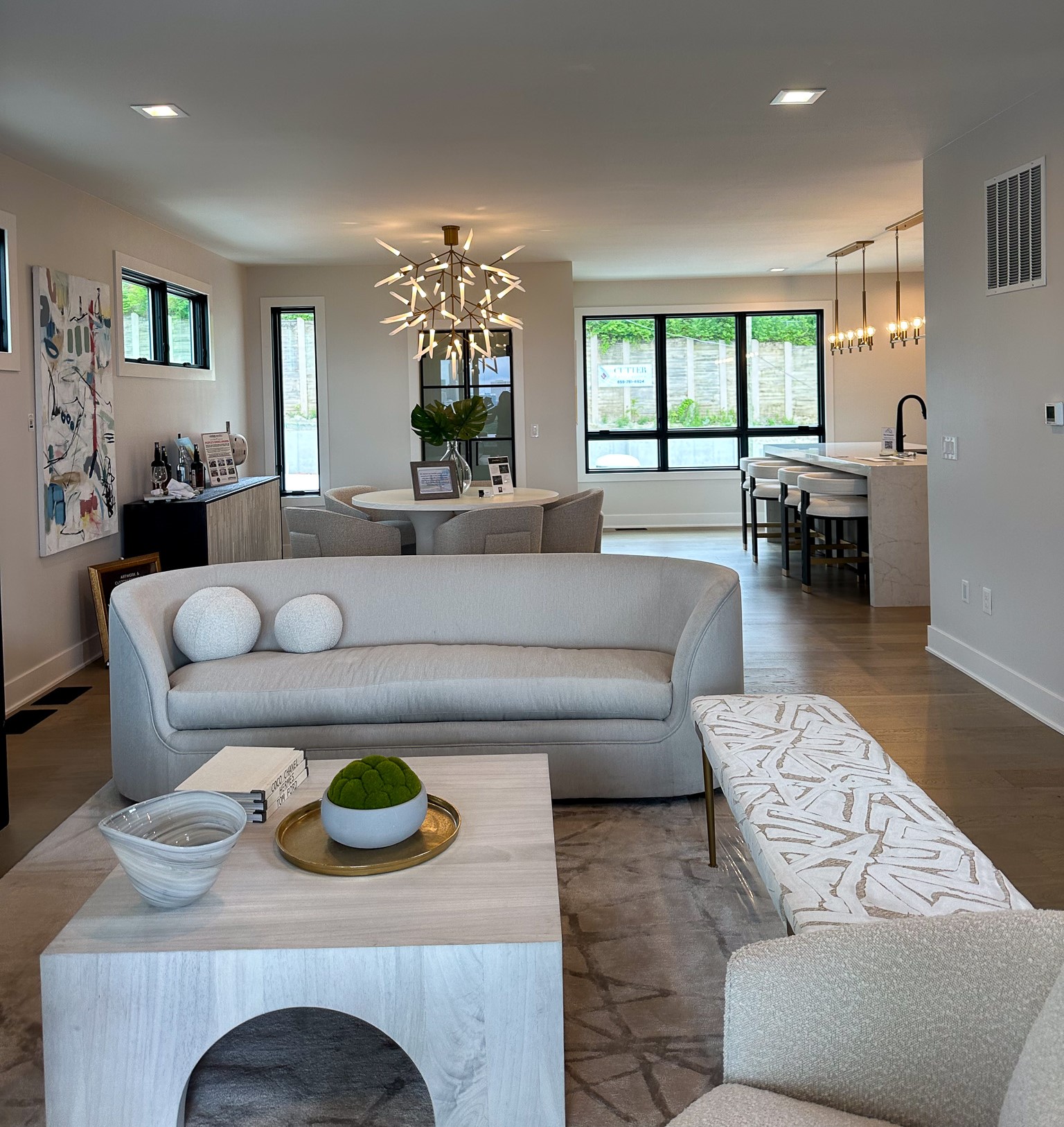 Neutral Livingroom at Homearama 2023 with contemporary style couch, dining table, and colorful artwork.
