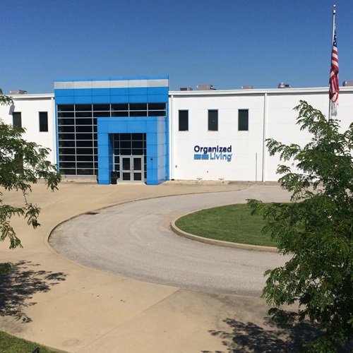 Organized Living's Manufacturing and Distribution Center building with trees, American flag, and front entrance.
