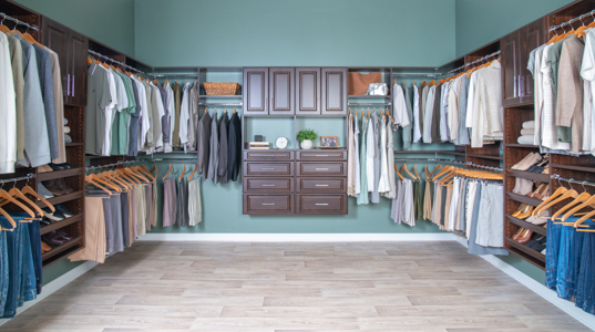 Select Walk-in Closet in Chocolate Pear with green walls and men and women clothing.