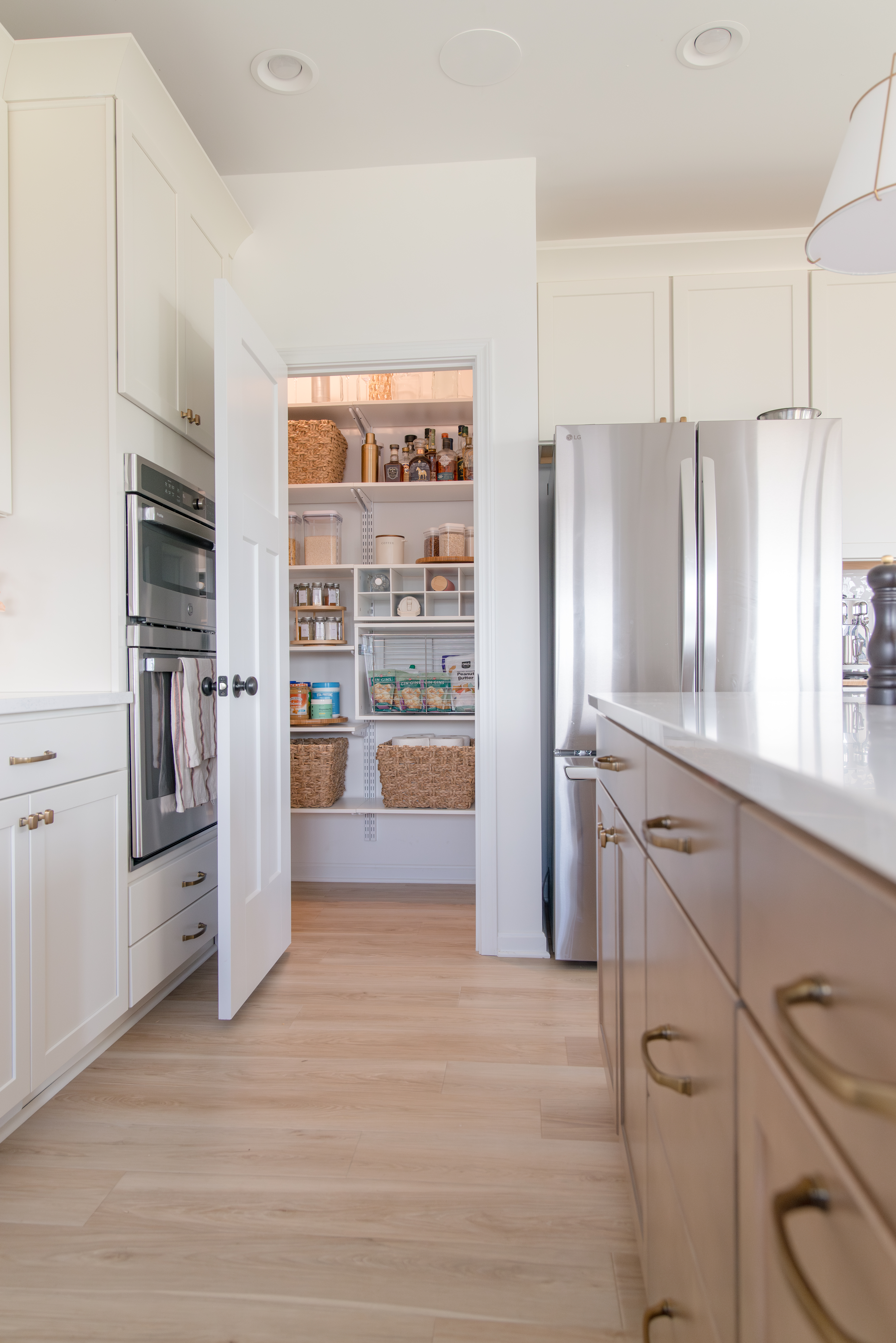 freedomRail Pantry in White with wire basket, dry goods, and wicker baskets.