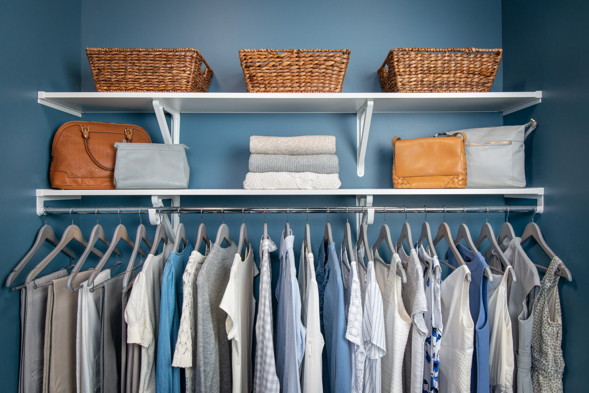 VUE_Bedroom_White with women's clothing, baskets, blue background and handbags.