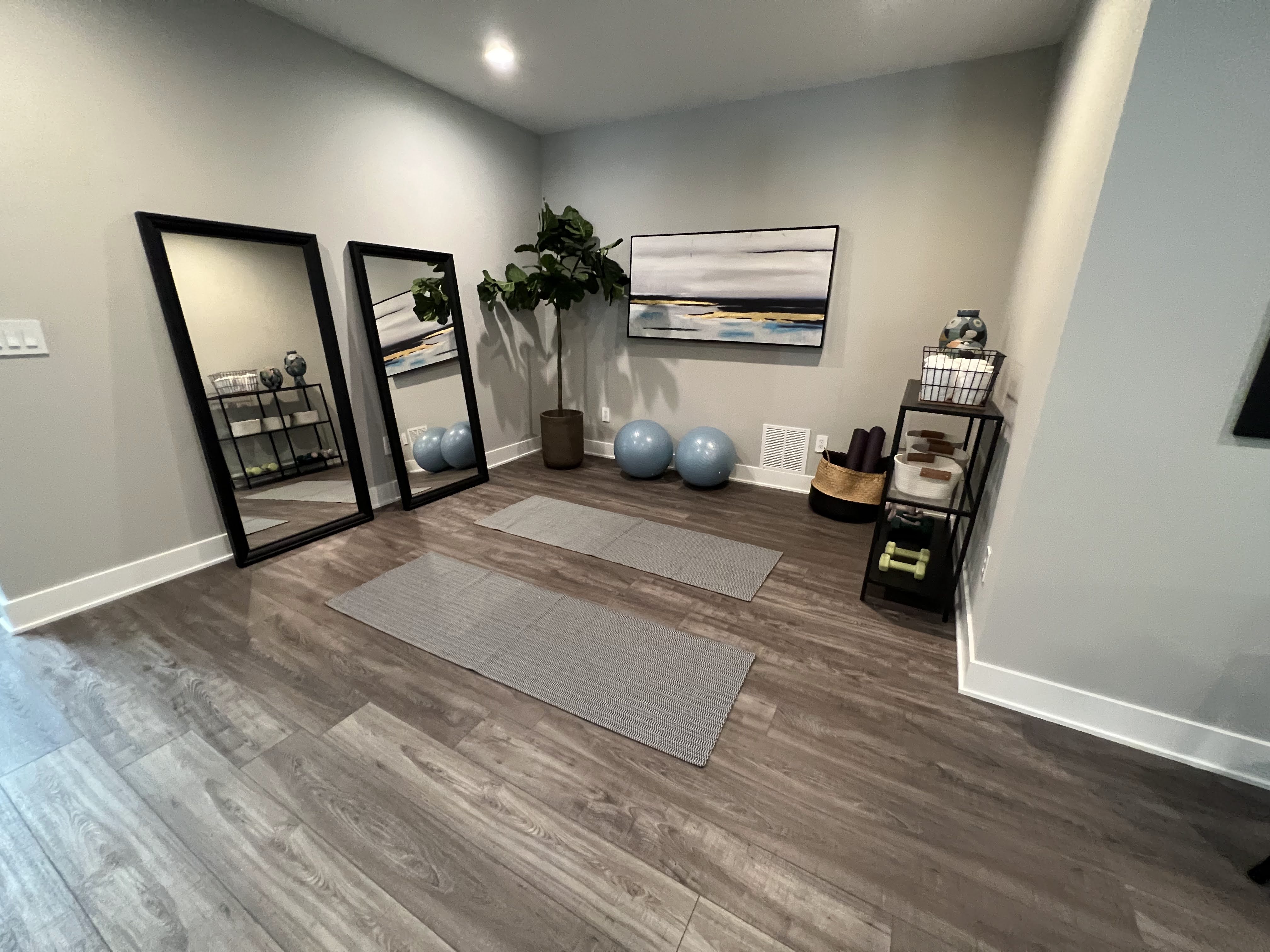 Workout area in home with yoga mats and mirrors.