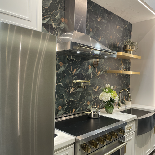 Dark Kitchen Display at IBS 2025 with stainless steel refrigerator, dark and moody floral wallpaper, and gold shelves.