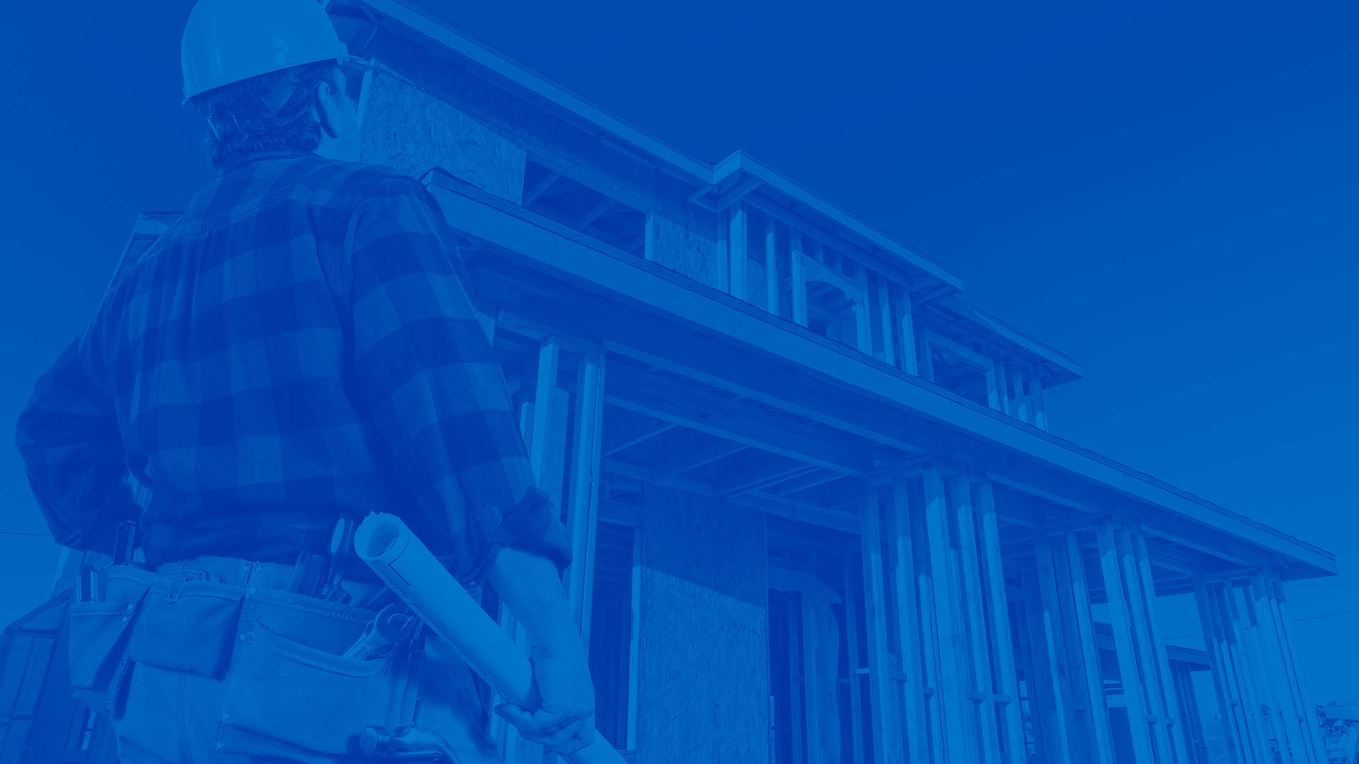 Single Family Builder with blue prints staring at house being built