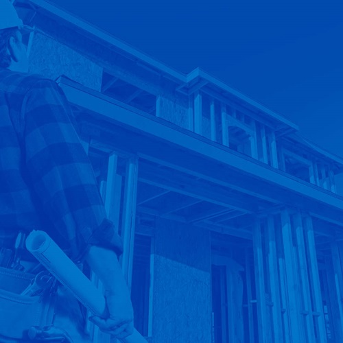 Single Family Builder with blue prints staring at house being built
