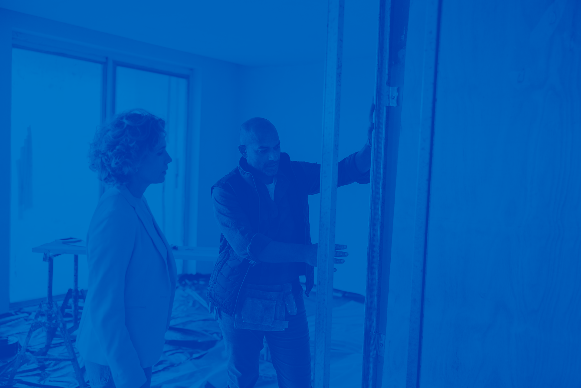 Builder and homeowner inside of home discussing plans for a closet layout.