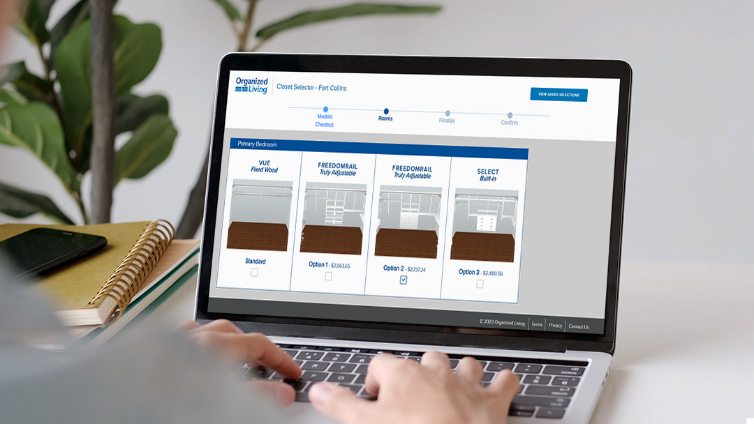 Closet Selector on Laptop with person typing, and there is a plant in the background.