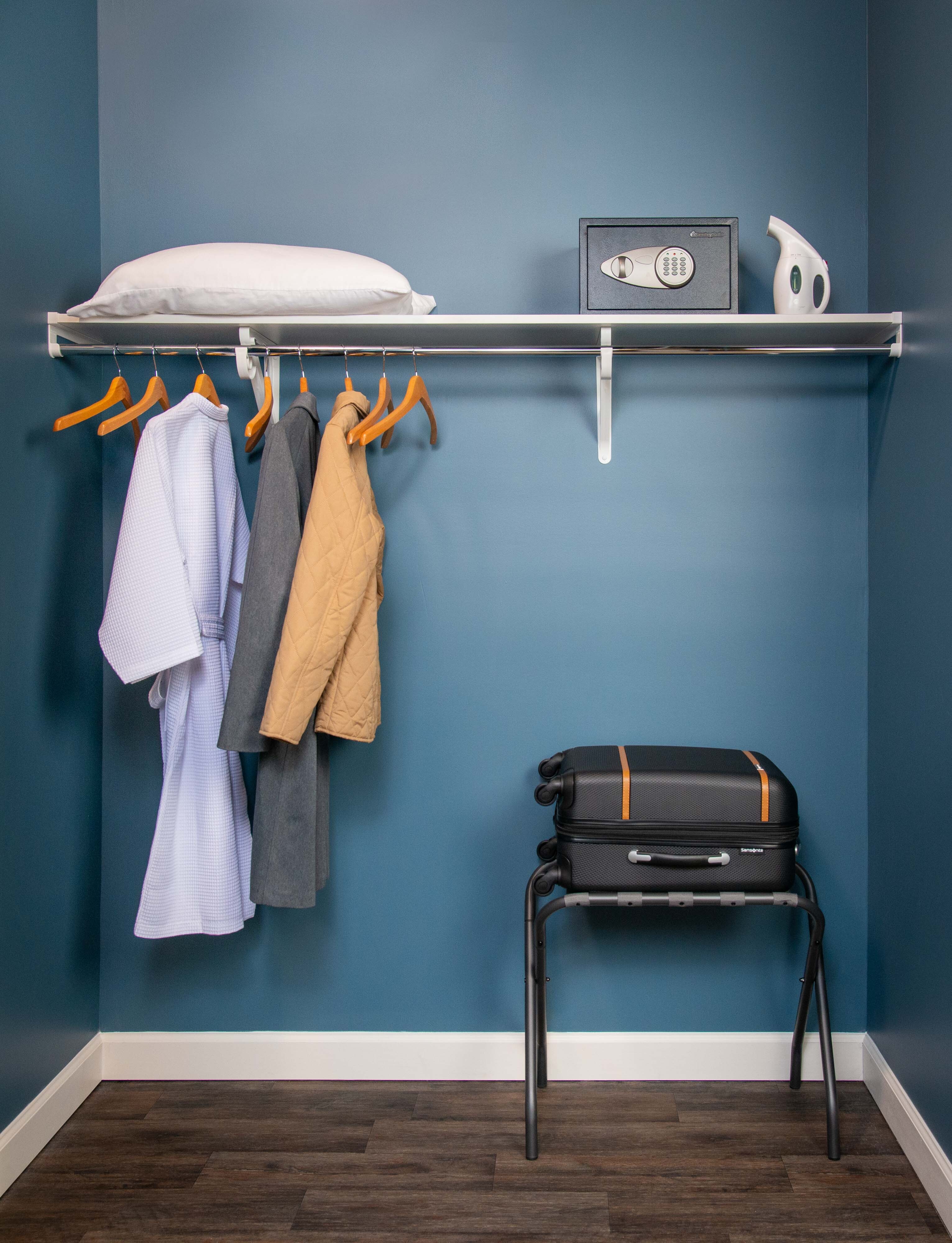 VUE Closet in White with luggage and blue background.