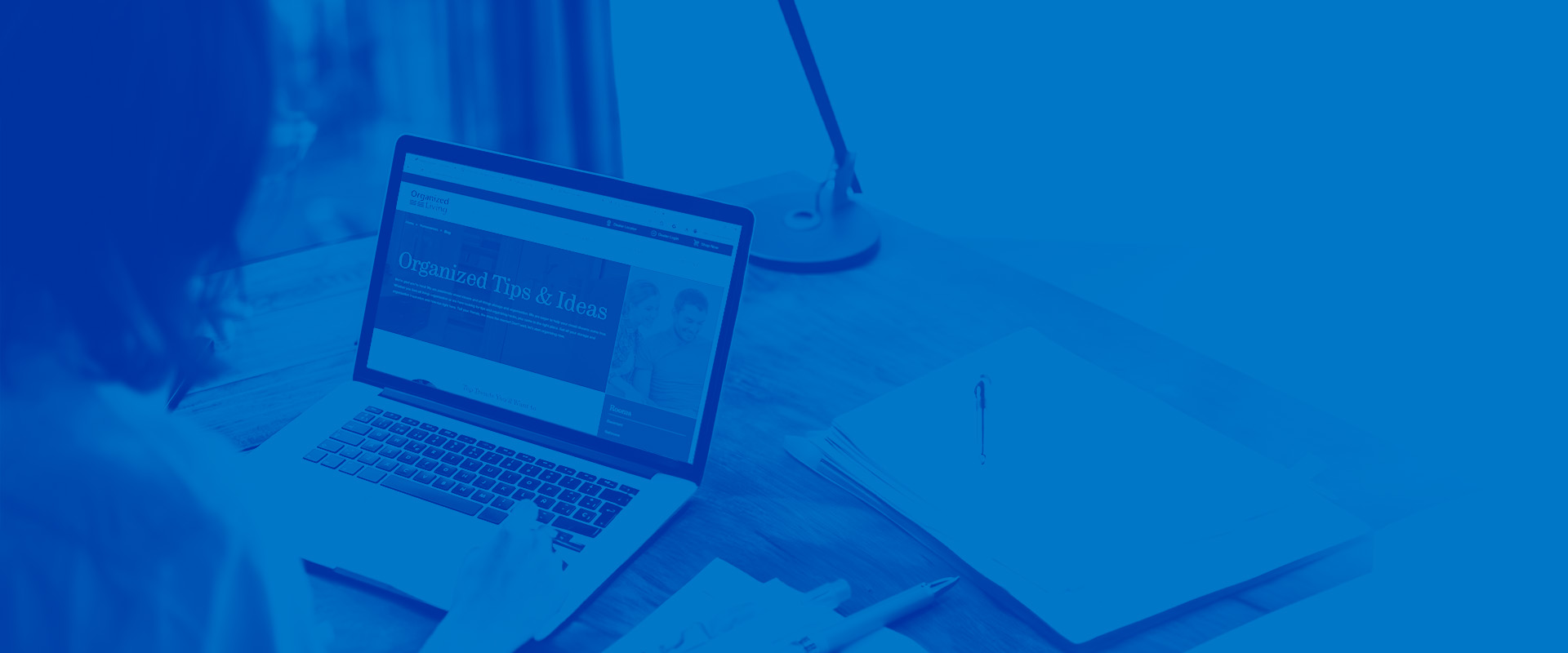 Woman using laptop. She is on Organized Living's Design Tool. There is a blue overlay on top of the image.