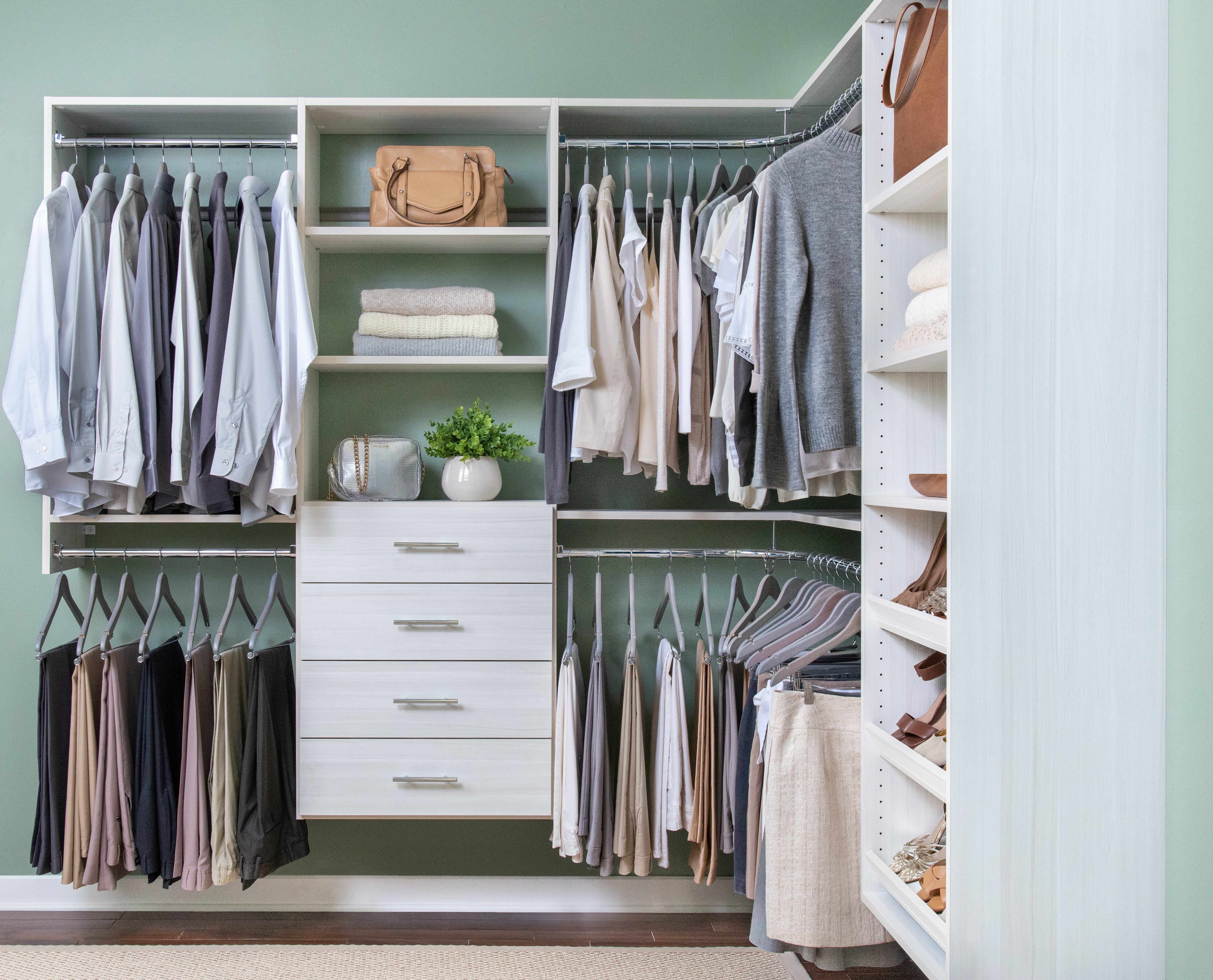 Select Primary Bedroom Walk-in Closet in White with clothes and navy walls.
