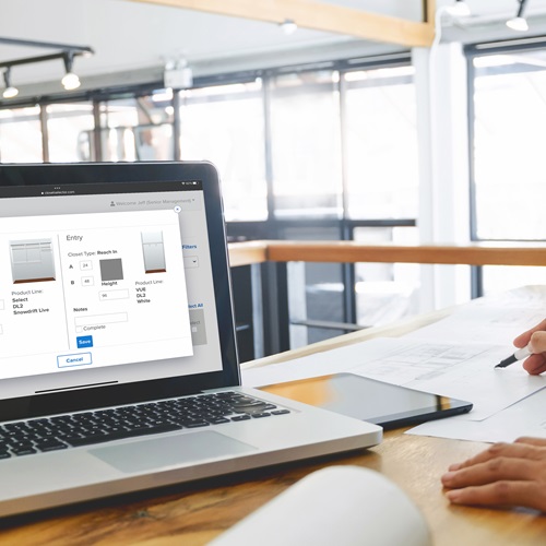 Bid360 on laptop with person using a pencil on some plans.
