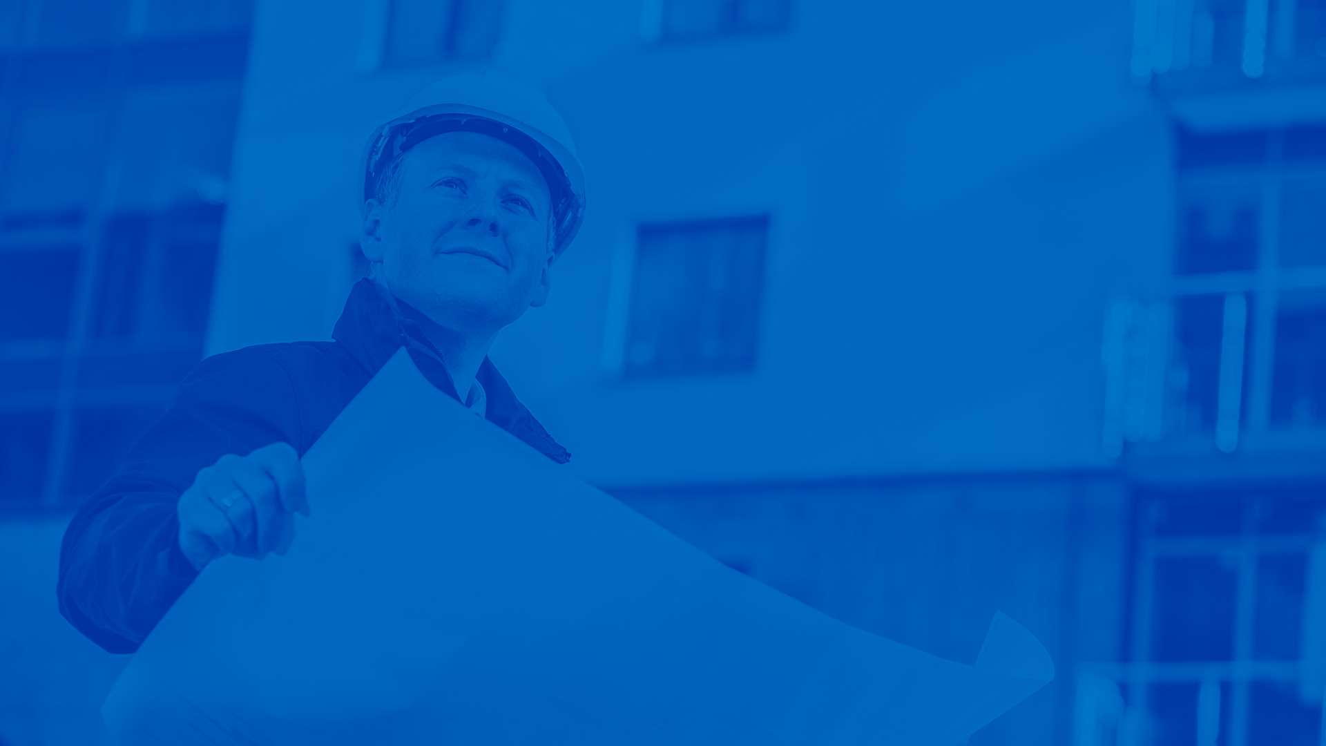 Male developer looking at plans. Blue overlay over image.