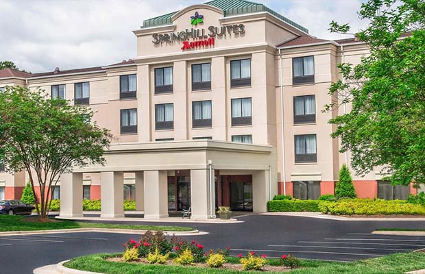Four-story Marriott Hotel with trees in front.