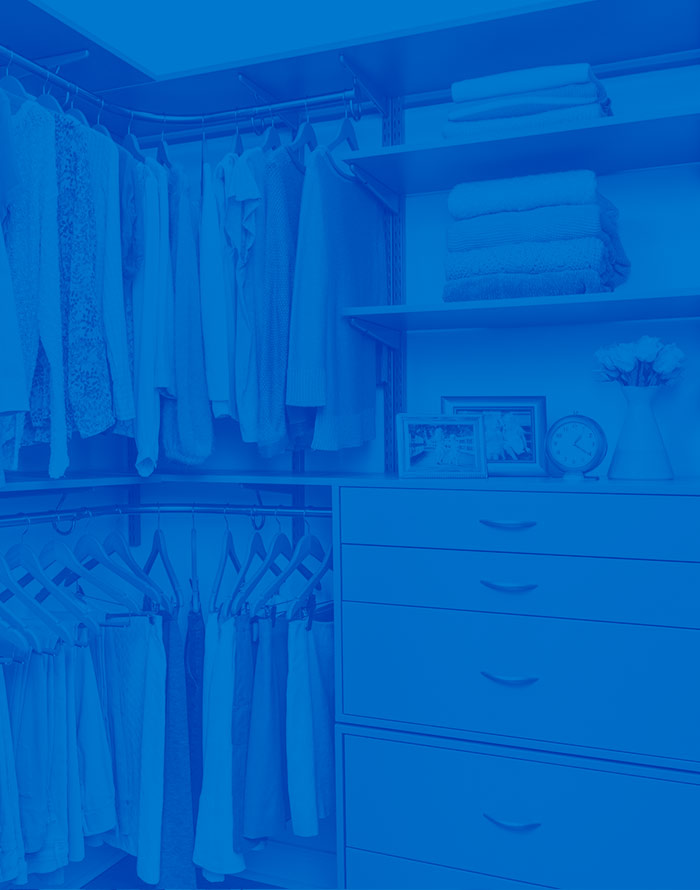 Walk-in freedomRail closet with drawers, clothes and folded sweaters