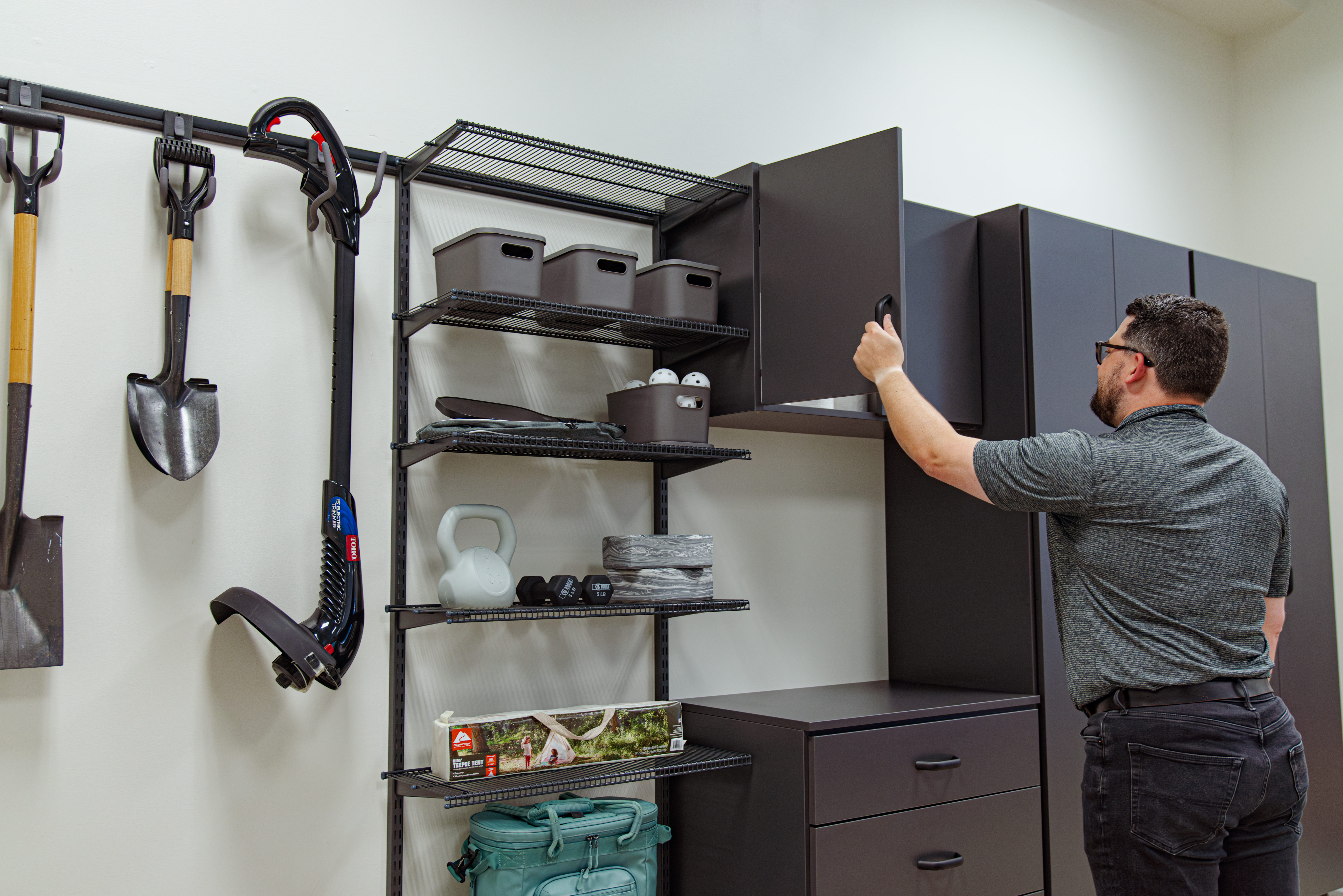 freedomRail EDGE Garage line. Man opening upper cabinet.