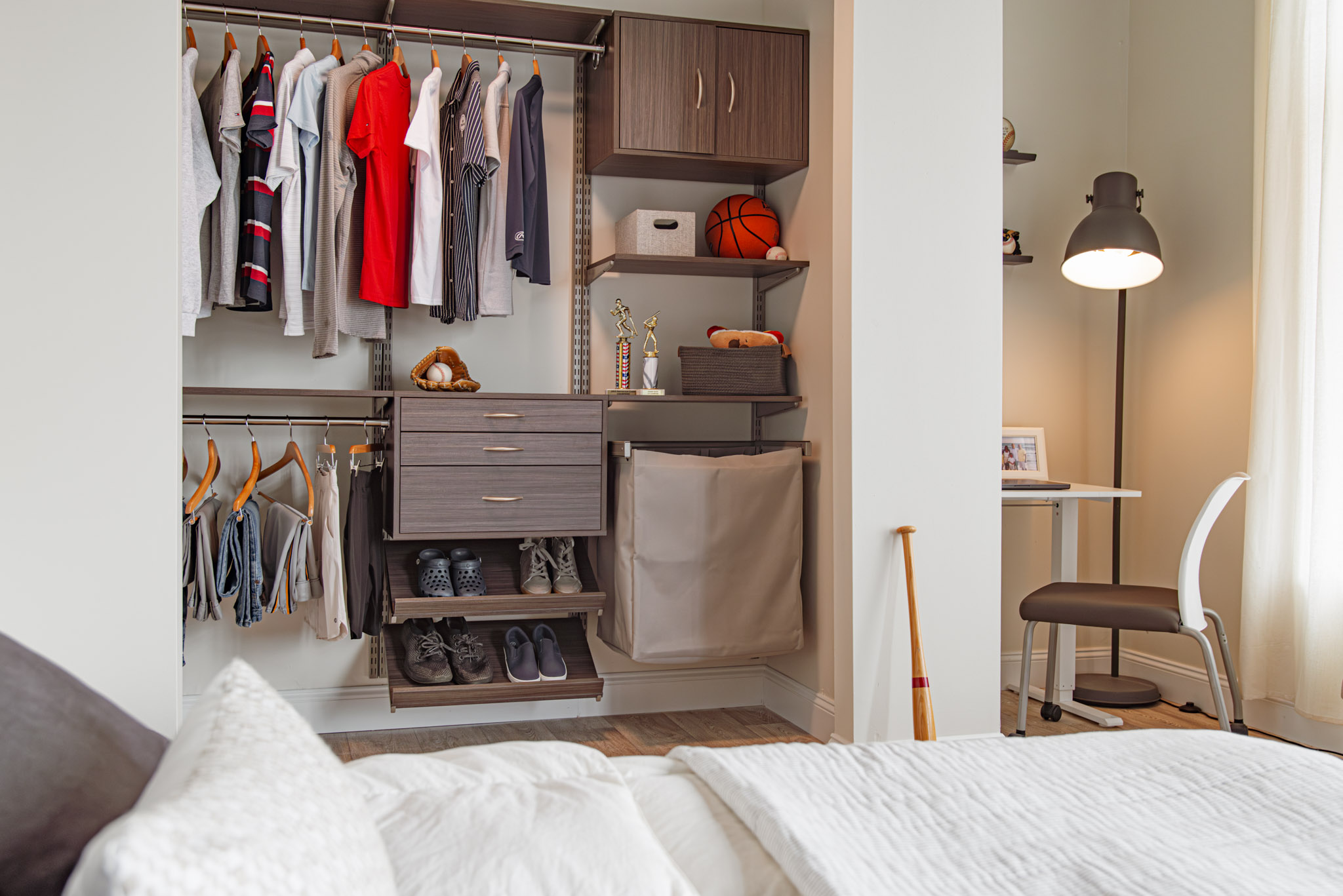 freedomRail Primary Reach-in Closet in White photograph with clothes and neutral background.