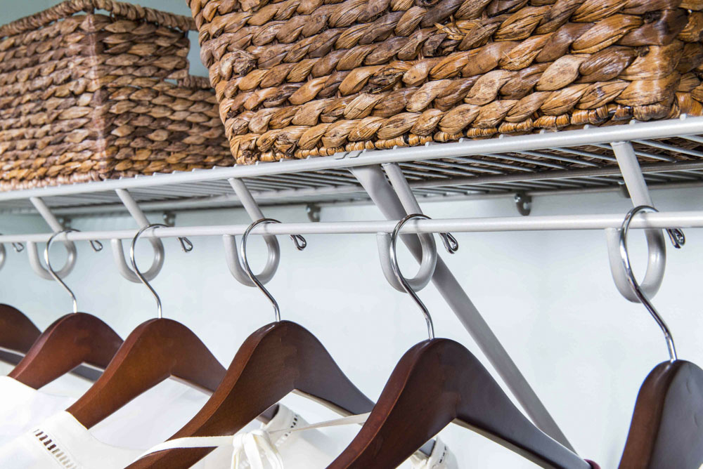 Limetime Ventilated Reach In Closet in Nickel. There are clothes hanging and 2 baskets.